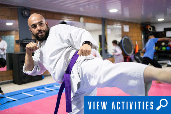 man in karate kick pose, click to register for martial arts